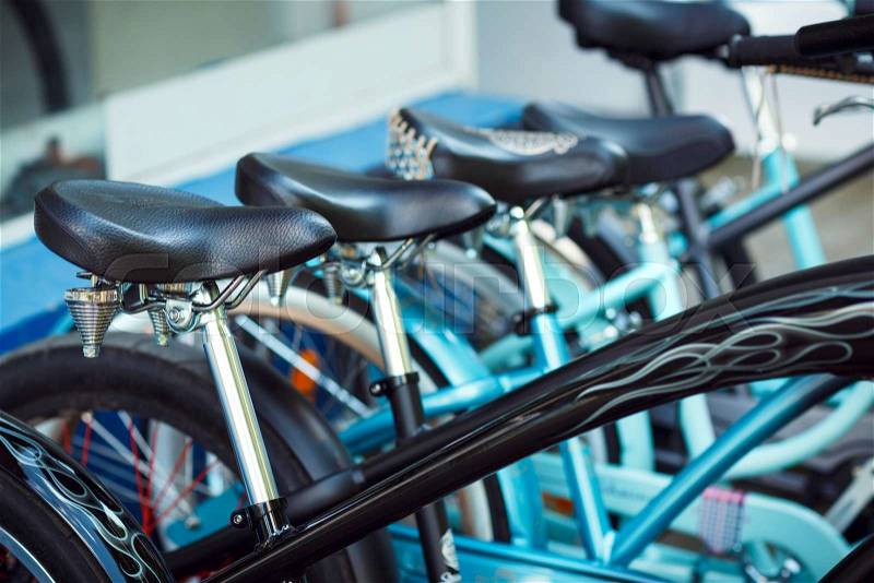 Close up of saddles of a group of bicycles on parking, stock photo
