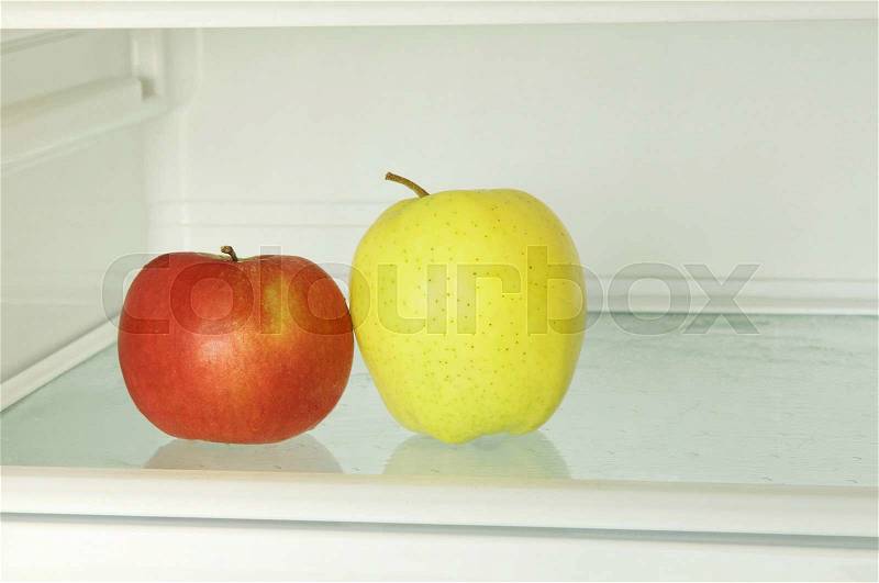 Healthy lifestyle.Red and yellow apple in domestic refrigerator taken closeup. Toned image, stock photo