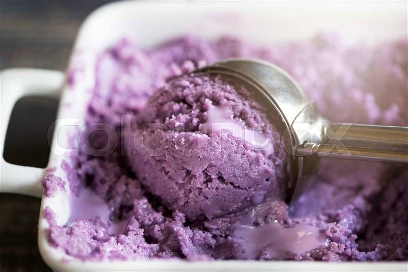 Scoop of blueberries ice cream in metal spoon,selective focus , stock photo