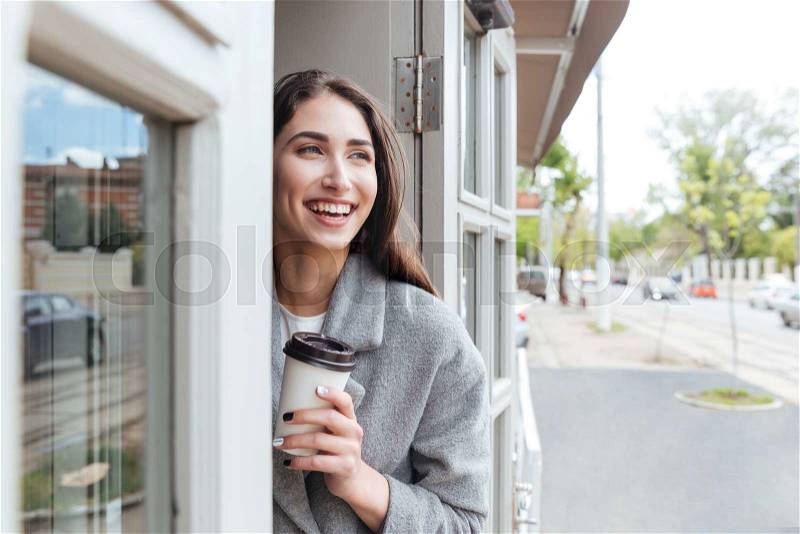Happy cheerful smiling girl holding take away coffee at the restaurant, stock photo