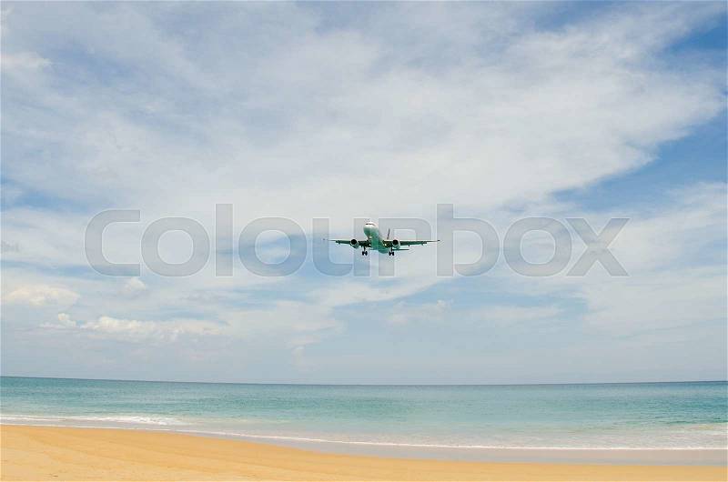 Airplane landing at airport, runway near the beach, stock photo