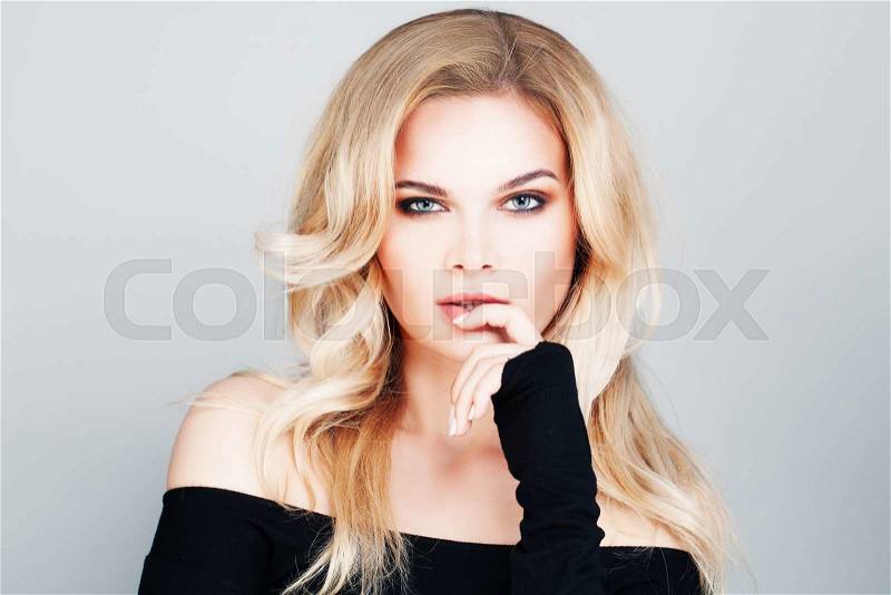 Blonde Woman with Wavy Permed Hairstyle and Makeup, stock photo