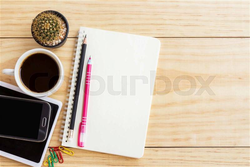 Vintage office desk table with notebooks,smart phone, pen and a cactus with cop of coffee. Top view with copy space. , stock photo