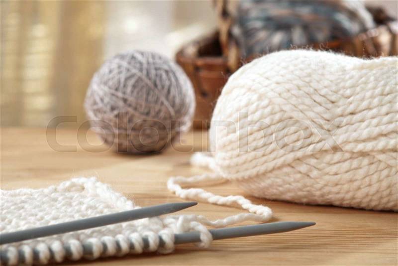 Knitting needles and yarn on wooden table, still life photo with soft focus, stock photo