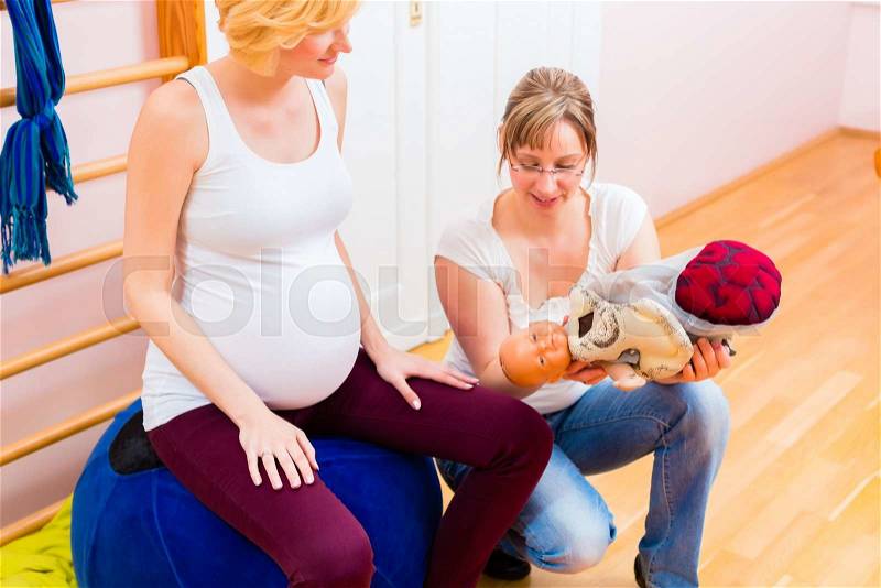 Midwife giving pregnant woman antenatal care for childbirth in practice , stock photo