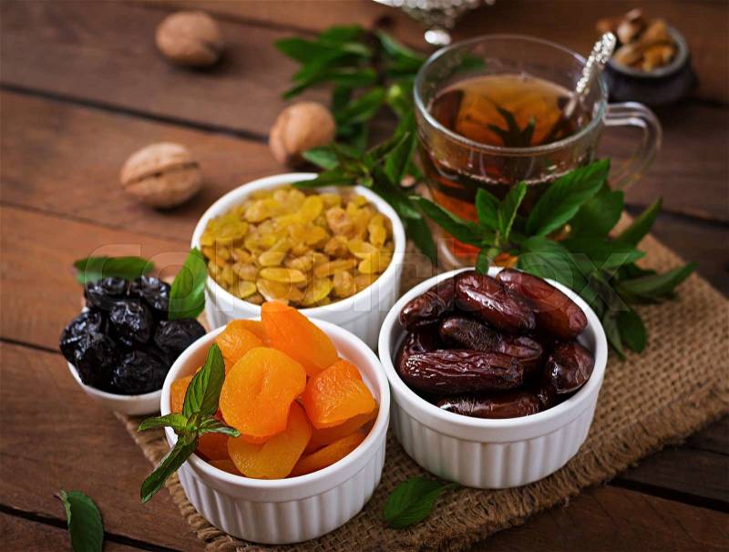 Mix dried fruits (date palm fruits, prunes, dried apricots, raisins) and nuts, and traditional Arabic tea. Ramadan (Ramazan) food, stock photo