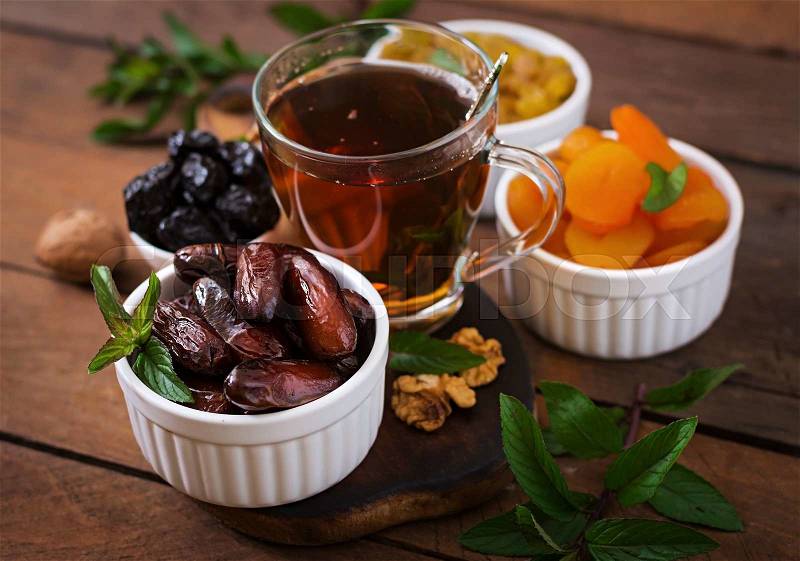 Mix dried fruits (date palm fruits, prunes, dried apricots, raisins) and nuts, and traditional Arabic tea. Ramadan (Ramazan) food, stock photo