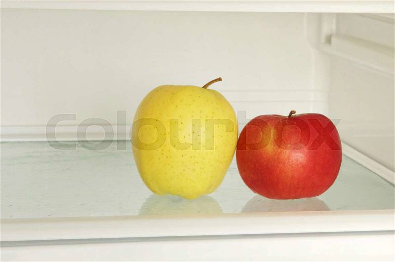 Healthy lifestyle.Red and yellow apple in domestic refrigerator taken closeup. Toned image, stock photo