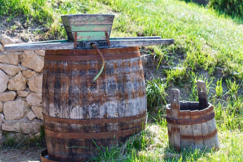 Old rusty wine press with oak barrel at the backyard, stock photo