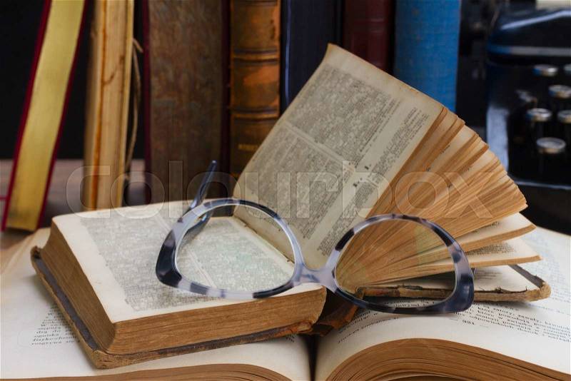Old books, glasses and typewriter - writting and publishing concept, stock photo