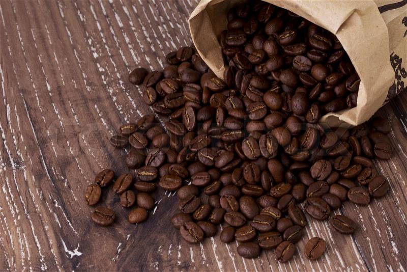 The coffee beans on a wooden background, stock photo