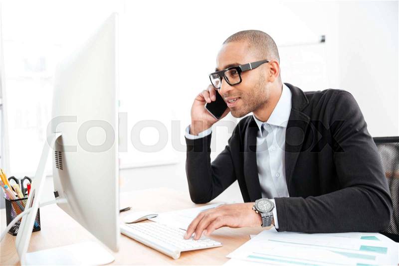 Office worker calling on the phone and reading business document in the office, stock photo