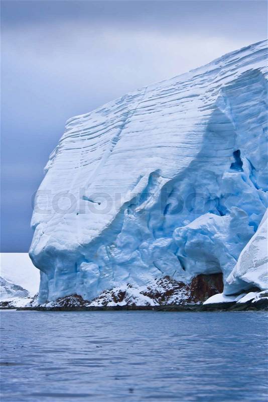 Huge Antarctic iceberg in the snow, stock photo