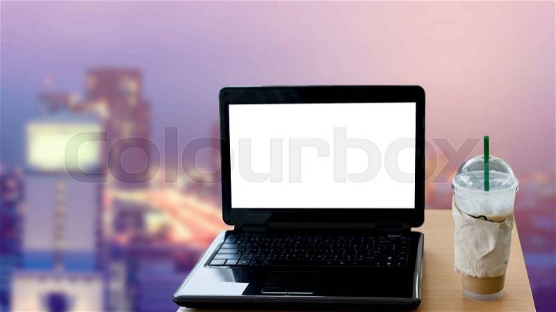 Blank screen laptop on table and blur cityscape background background, stock photo