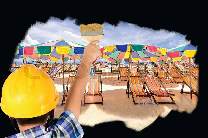 Boy engineering ideas concept with hand holding brush tool With painting sky, sea,sand and umbrella for summer concept, stock photo
