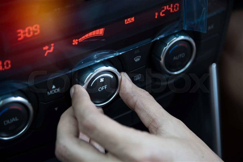 Man hand adjust fan speed in car, stock photo