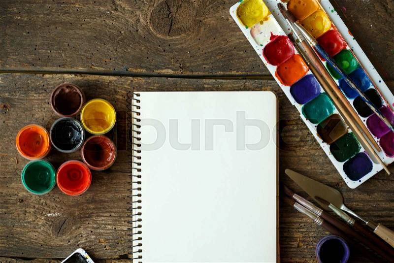 Art of Painting. Painting set: paper, brushes, paints, watercolor, acrylic paint on a wooden background top down view, stock photo