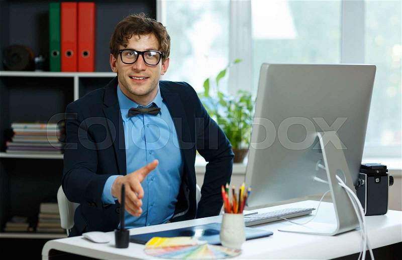 Modern young business man with arm extended to handshake, stock photo