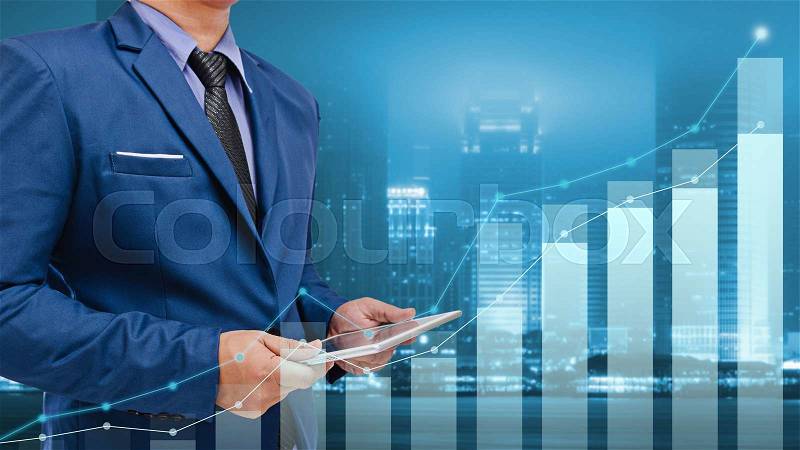 Business man using tablet monitor graph on screen with night city background, stock photo