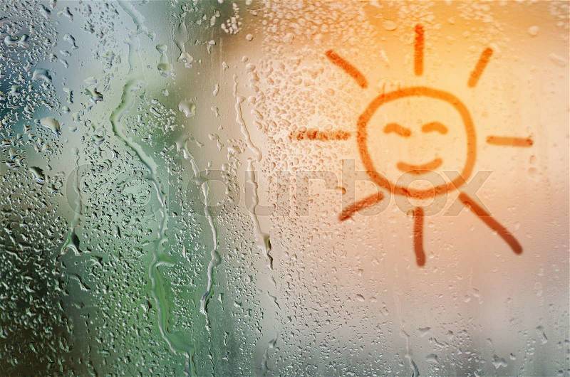 Draw sun on natural water drops glass window background, stock photo