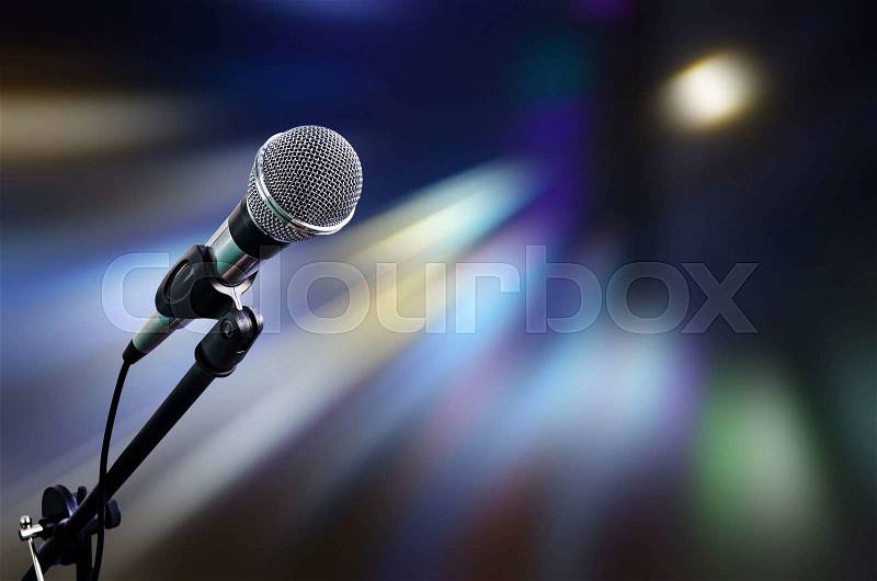 Microphone on stage with moving light background, stock photo