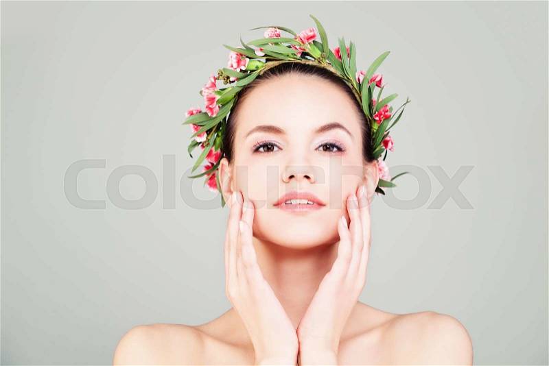 Spa Woman with Summer Flowers Wreath. Natural Beauty. Model touch her Face her Hand , stock photo