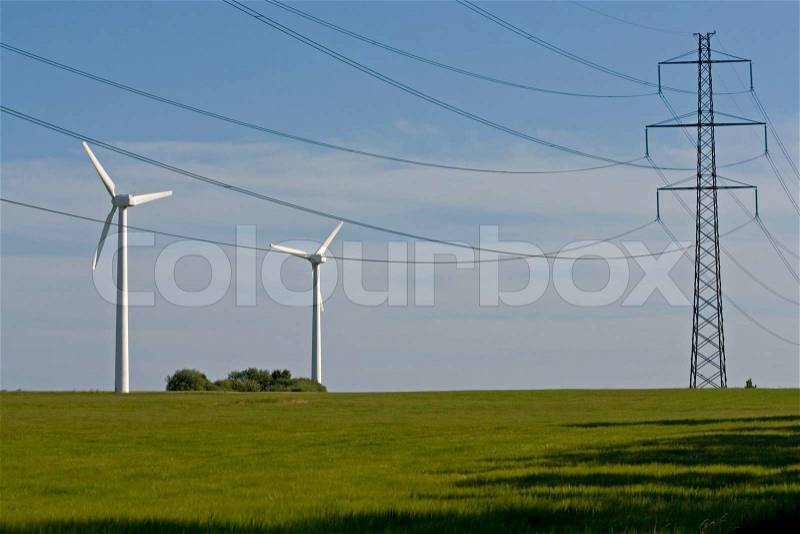 Windmills side by side by traditionel powerlines, stock photo