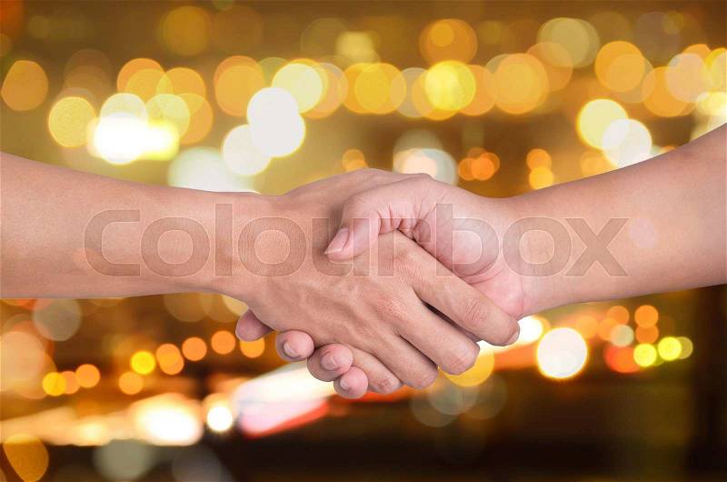Two man shaking hands on city bokeh background, stock photo