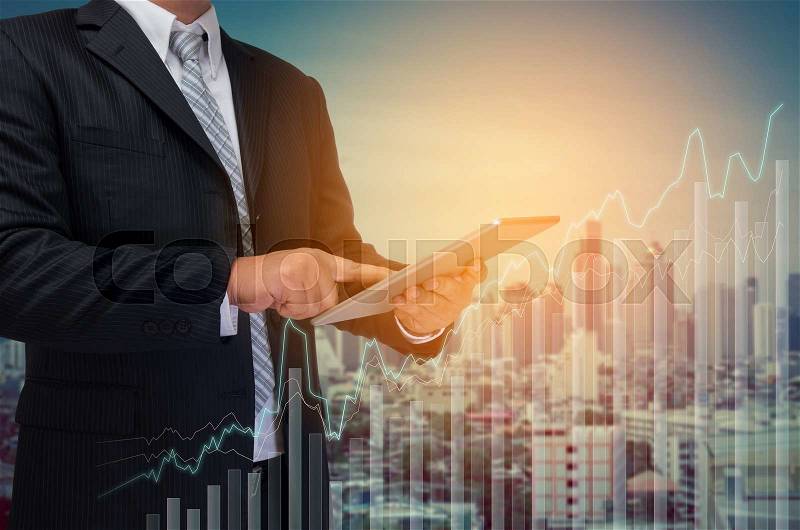 Business man using tablet monitor graph on screen with city background, stock photo