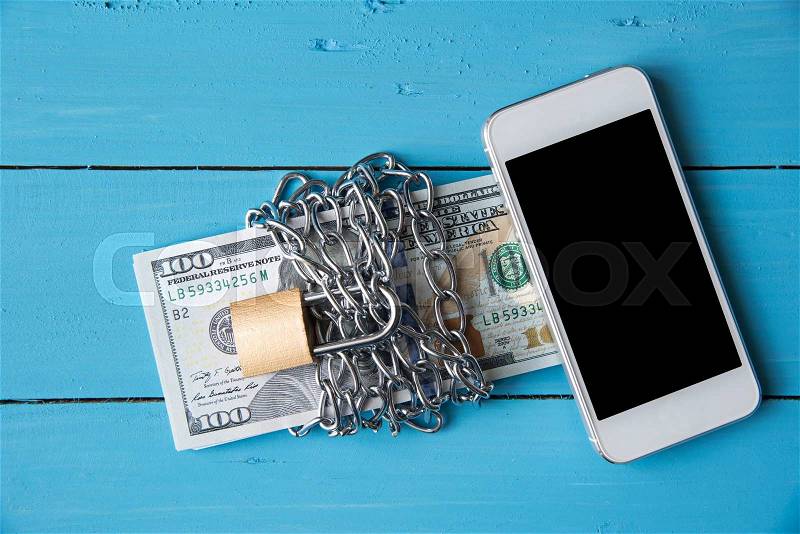 Phone and locked dollar money by metal chain link with padlock, stock photo