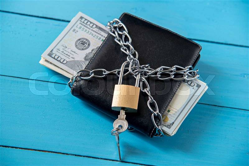 Locked dollar money purse with metal chain link with padlock, stock photo