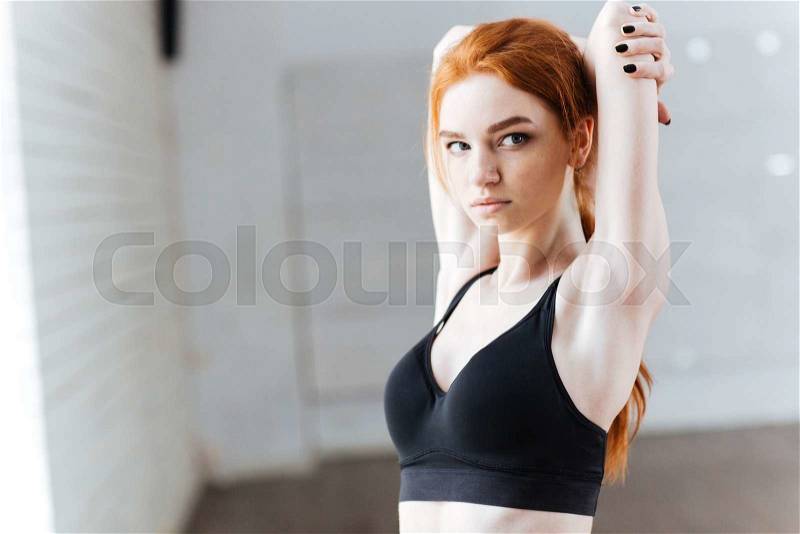 Close-up portrait of a beautiful young fitness woman streching at the gym, stock photo