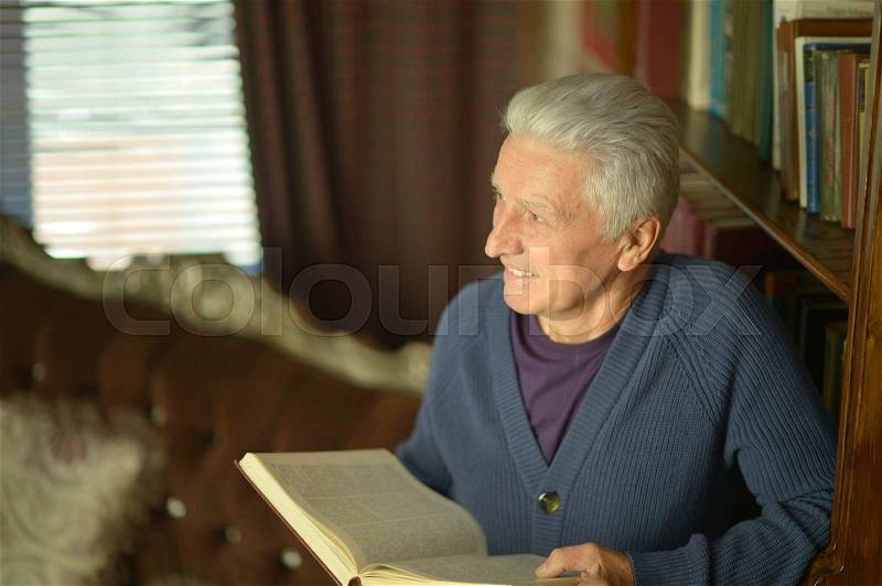 Handsome retired man reading booktrait of handsome retired man reading book, stock photo