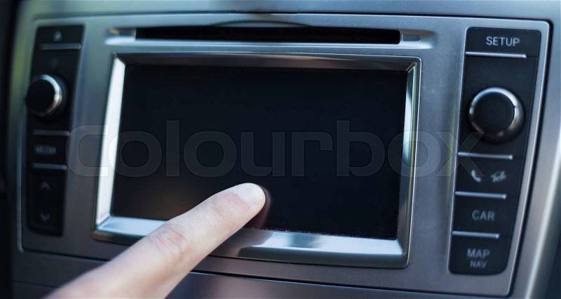 Male hand touching screen in modern car, stock photo