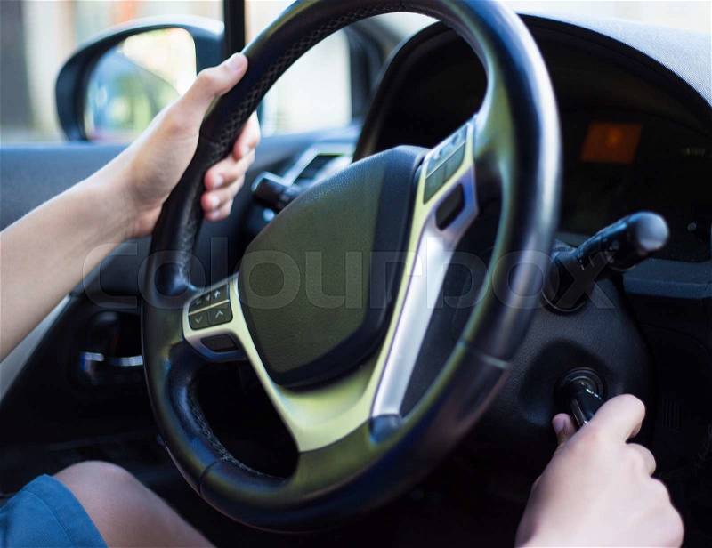 Young driver\'s hand holding car key for starting the car, stock photo