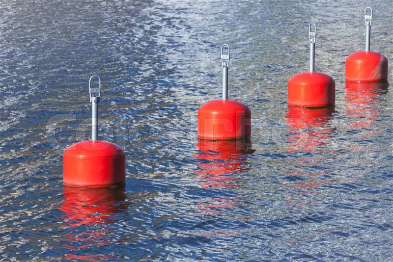Red mooring buoys in a row, European marina nautical equipment, stock photo