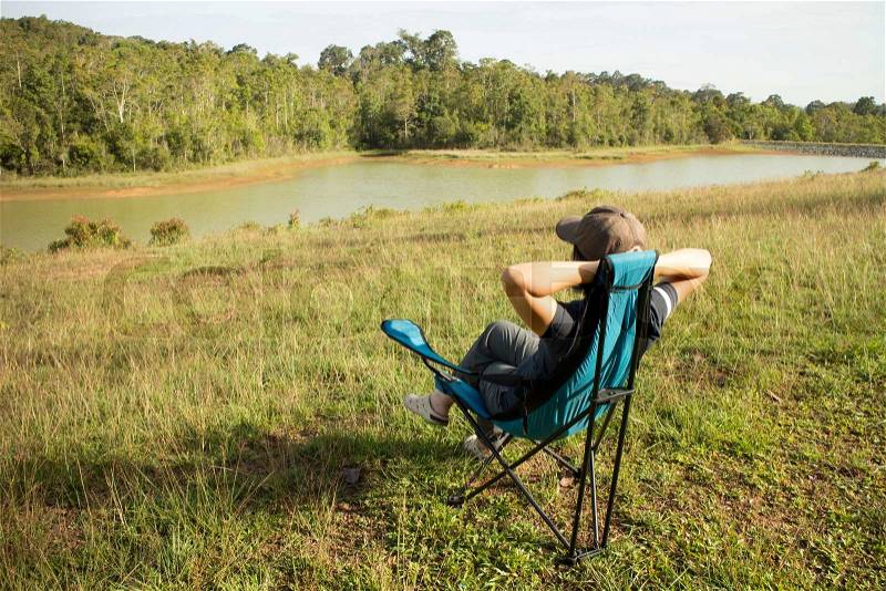 Thai woman sitting on the chair in the field at Khao Yai National park, Thailand, stock photo