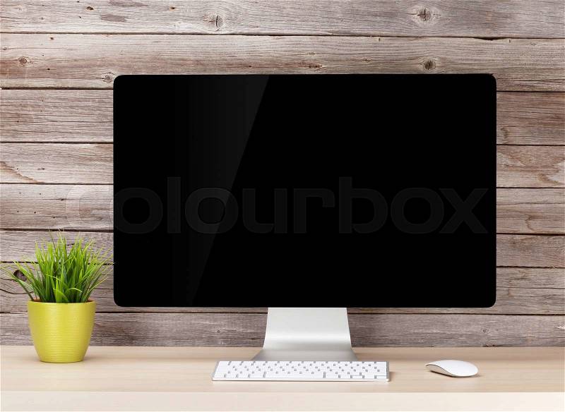 Office desk workplace with pc in front of wooden wall. Loft style, stock photo