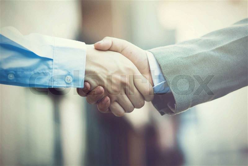Business handshake. Two businessman shaking hands (Vintage tone), stock photo
