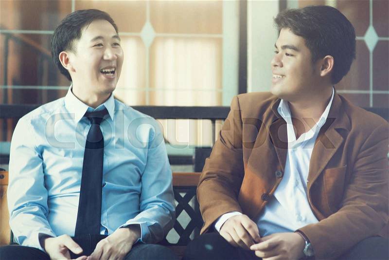Two Asian Business Men Discussing while Sitting (Vintage Tone), stock photo