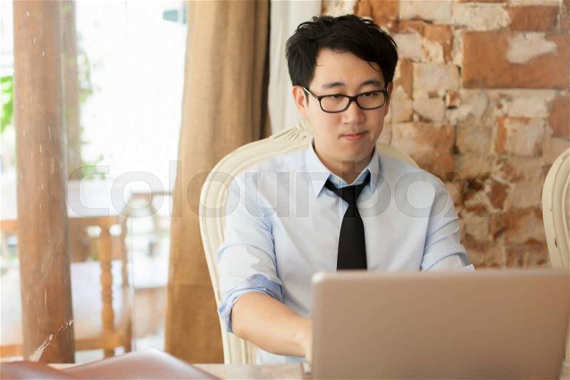Casual businessman working while looking boring in outdoor office, stock photo