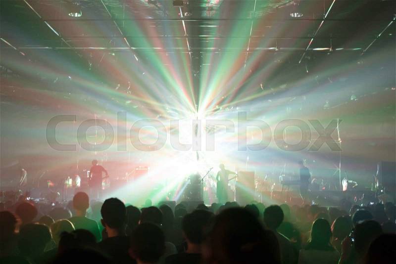 Music concert crowds illuminated from stage lights (very shallow depth of field), stock photo