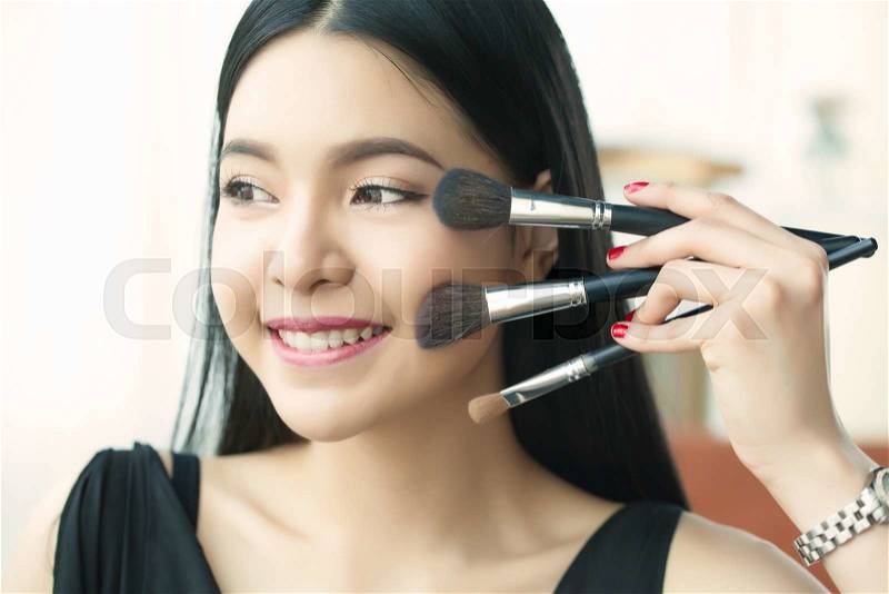 Asian woman holding brushes - beauty makeup concept, stock photo