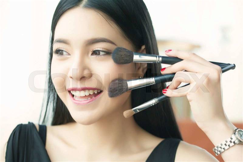 Asian woman holding brushes - beauty makeup concept, stock photo