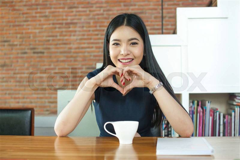 Asian Woman Smiling in front of coffee on the table, stock photo