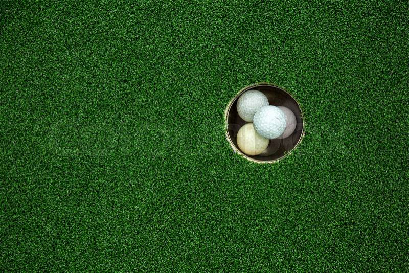 Top view of golf balls stacked up in green field, stock photo