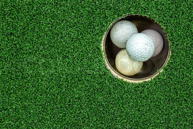 Top view of golf balls stacked up in green field, stock photo