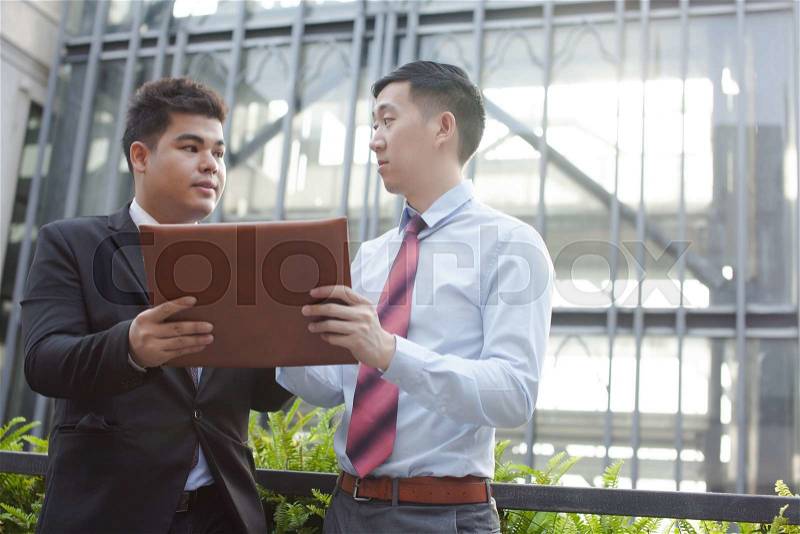 Young professionals discussing business outdoor, stock photo