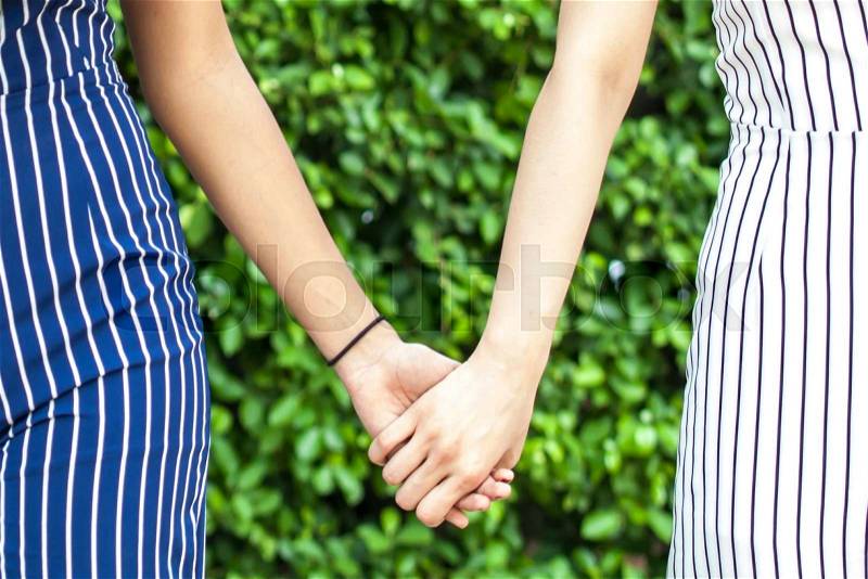 Female best friend forever holding hands together - friendship and love concept, stock photo