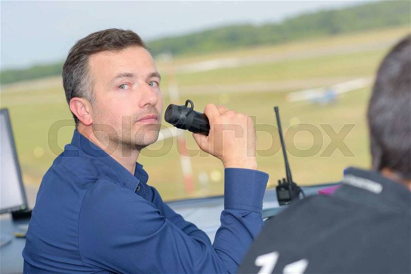 Man in control tower talking into radio receiver, stock photo